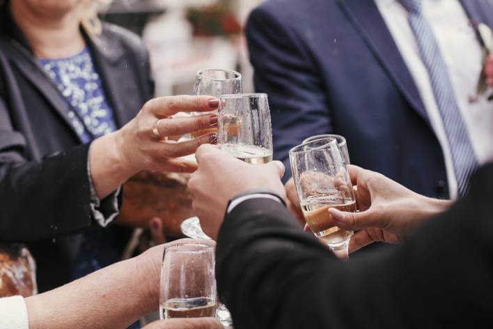 close up of hands holding champagne glasses