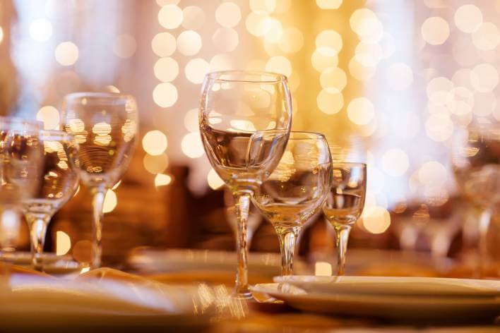 wine glasses on table with twinkling lights in background