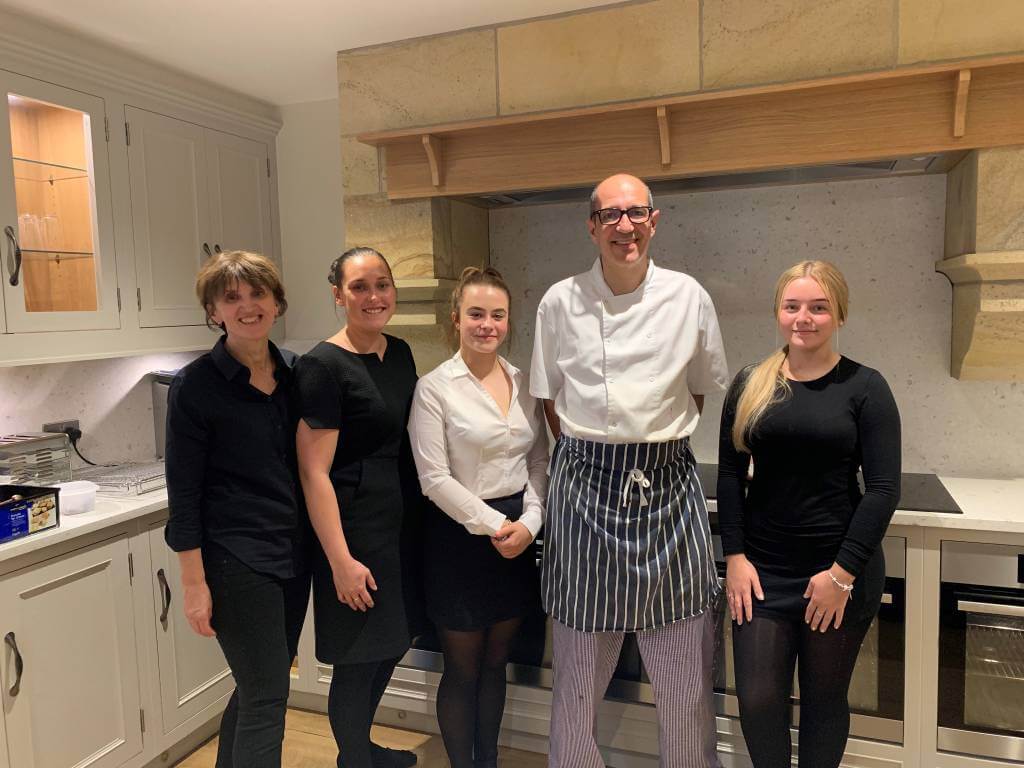 Chef and waiting staff in kitchen