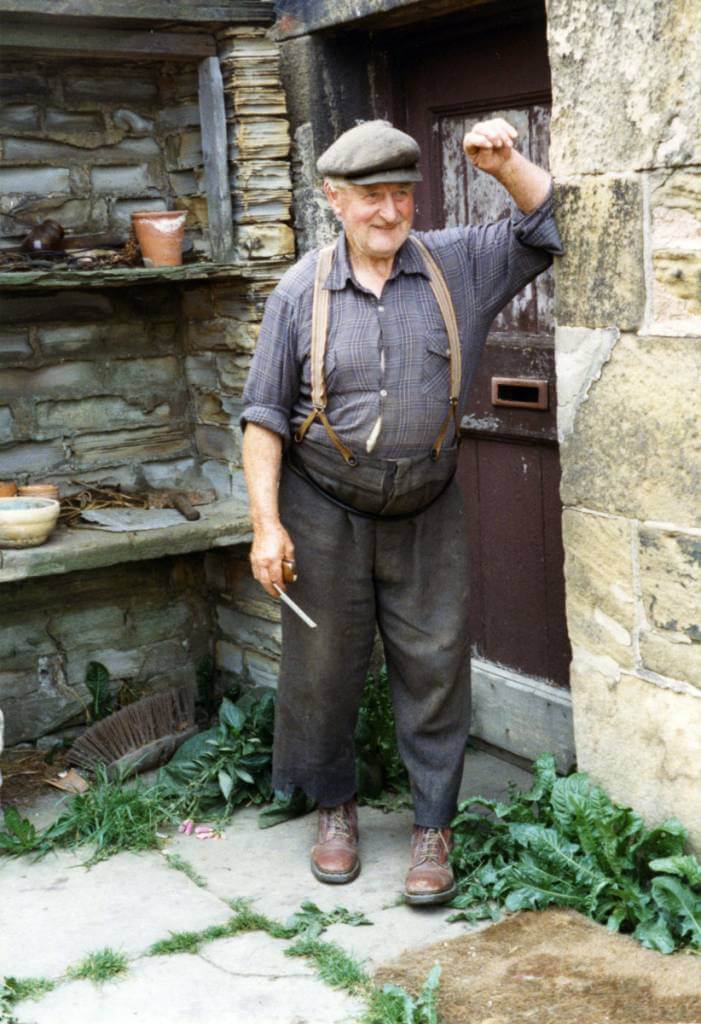 Working man wearing cap leaning against wall