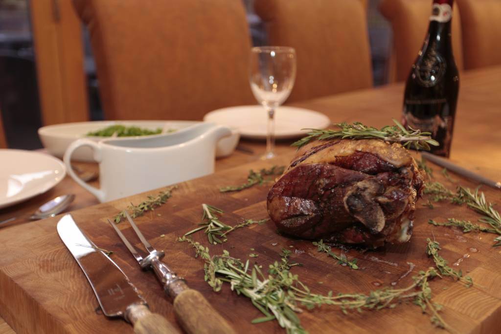 Meat on carving board with herbs