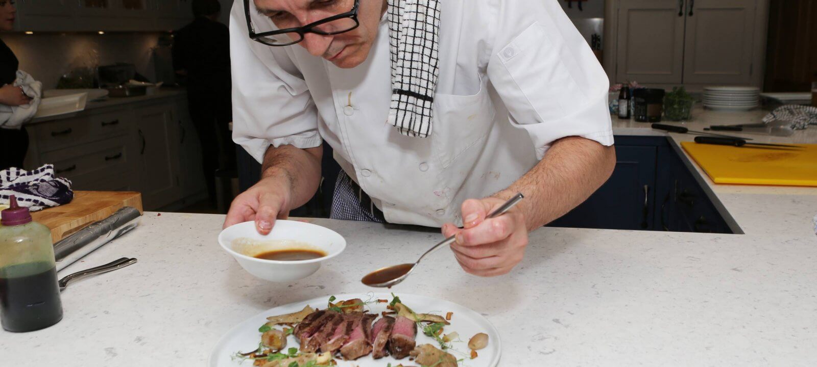 Chef adding finishing touches to meat dish