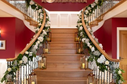 stairs and landing decorated with garlands of flowers and lanterns
