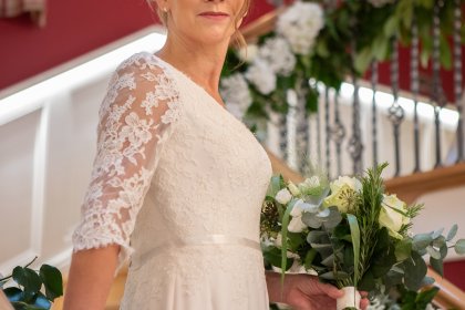 Bride standing on stairs holding bouquet of flowers