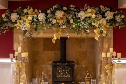 Garland of flowers and candles decorating fireplace