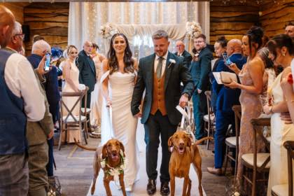 Bride walking down aisle with dogs